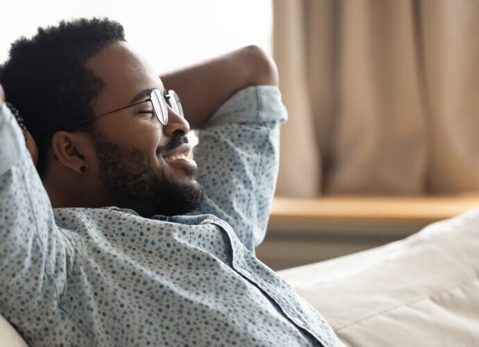 Homem sorridente sentado em um sofá