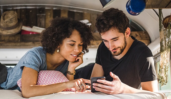 Um homem e uma mulher olhando para um celular